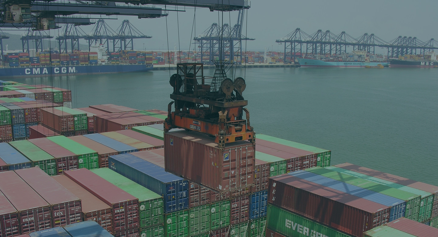 Image of a container port with ships in the background.